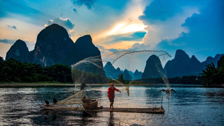 Cormorant fisherman on a bamboo raft among the karst peaks of the Li River, Guilin