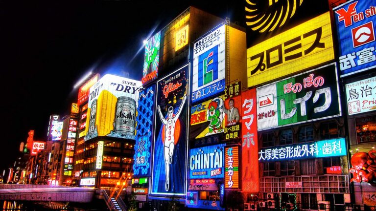 Neon signs reflecting on the Dotonbori canal at night in Osaka, Japan