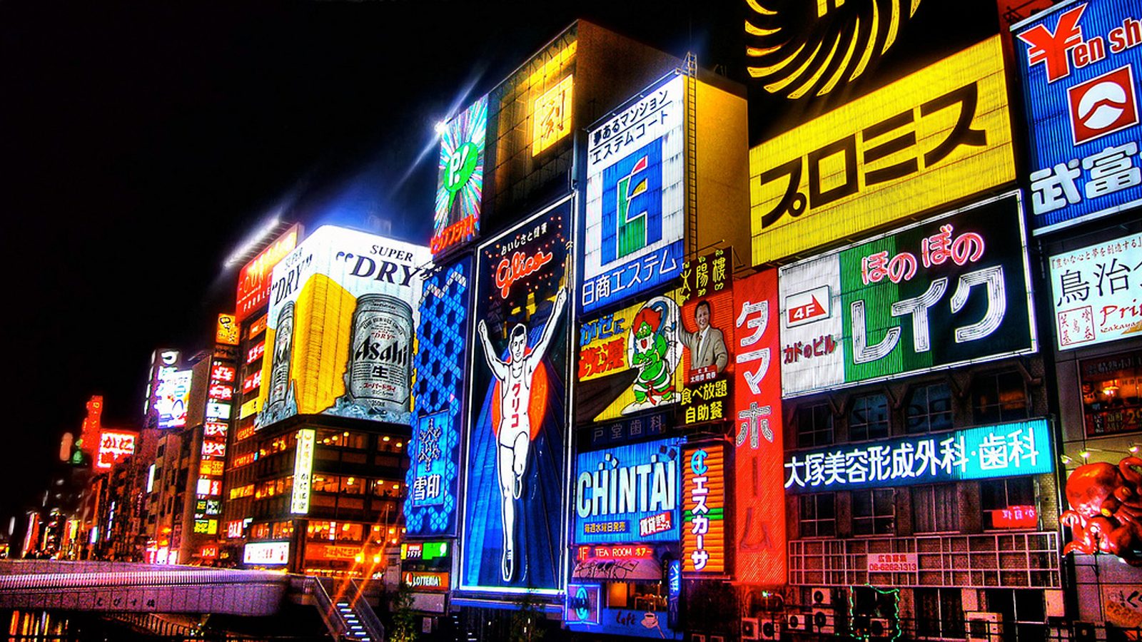 Neon signs reflecting on the Dotonbori canal at night in Osaka, Japan